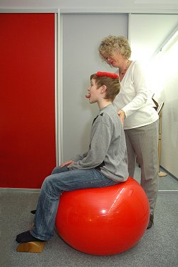 Konzentrationsübung auf dem Ball mit Schokolinse